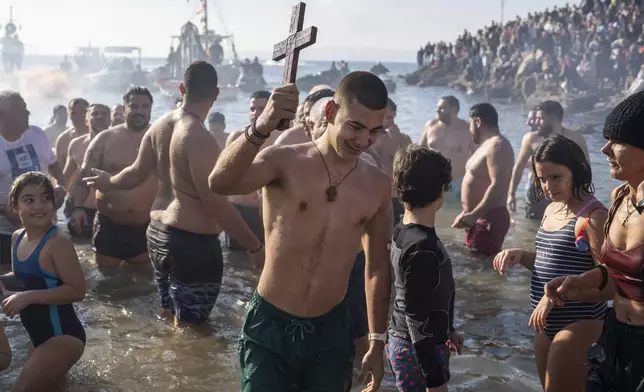 Marcos-Poseidonas Kavalaris reacts after retrieving the cross during a water blessing ceremony marking the Epiphany celebrations in Piraeus near Athens, on Monday, Jan. 6, 2025. (AP Photo/Petros Giannakouris)