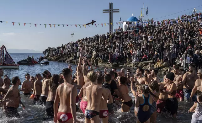 Pilgrims jump to catch the cross during a water blessing ceremony marking the Epiphany celebrations, in Piraeus near Athens, Monday, Jan. 6, 2025. (AP Photo/Petros Giannakouris)