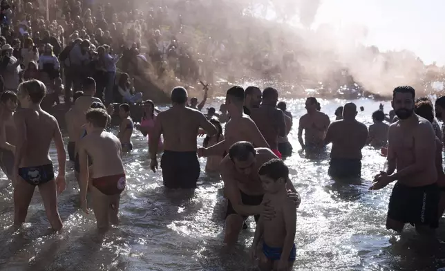 Pilgrims catch the cross during a water blessing ceremony marking the Epiphany celebrations, in Piraeus near Athens, on Monday, Jan. 6, 2025. (AP Photo/Petros Giannakouris)