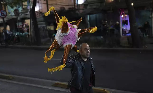 A volunteer of the group known as the Punk Kings loads a truck to distribute toys, clothes and pinatas to disadvantaged children in celebration of Epiphany, or Three Kings Day, in Mexico City, Sunday, Jan. 5, 2025. (AP Photo/Eduardo Verdugo)