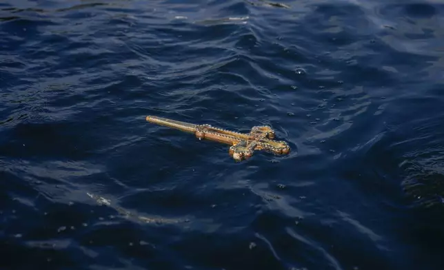 A wooden crucifix floats after being thrown in the Golden Horn during the Epiphany ceremony in Istanbul, Turkey, Monday, Jan. 6, 2025. (AP Photo/Khalil Hamra)