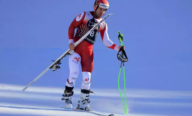 Austria's Vincent Kriechmayr skis on a single ski as he comes down the slope after crashing during an alpine ski, men's World Cup downhill, in Wengen, Switzerland, Saturday, Jan. 18, 2025 (AP Photo/Giovanni Maria Pizzato)