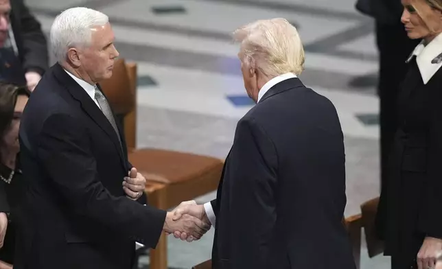 President-elect Donald Trump shakes hands with former Vice President Mike Pence as Melania Trump watches before the state funeral for former President Jimmy Carter at Washington National Cathedral in Washington, Thursday, Jan. 9, 2025. (AP Photo/Jacquelyn Martin)