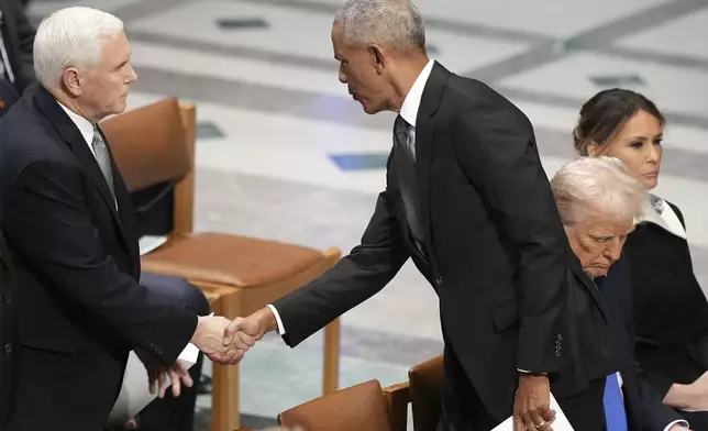 Former President Barack Obama shakes hands with former Vice President Mike Pence before the state funeral for former President Jimmy Carter at Washington National Cathedral in Washington, Thursday, Jan. 9, 2025, as President-elect Donald Trump sits with Melania Trump at right. (AP Photo/Jacquelyn Martin)