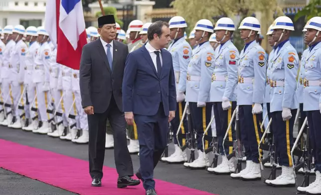 France's Defense Minister Sebastien Lecornu, right, and Indonesian Defense Minister Sjafrie Sjamsoeddin inspect honor guards during the welcoming ceremony prior to their meeting in Jakarta, Indonesia, Friday, Jan. 31, 2025. (AP Photo/Tatan Syuflana)
