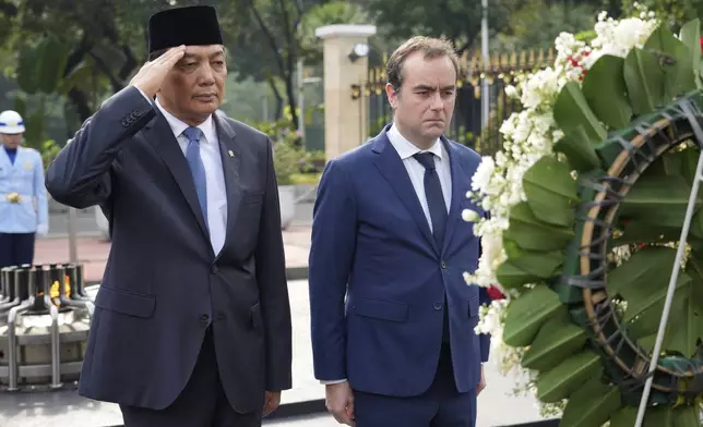 Indonesian Defense Minister Sjafrie Sjamsoeddin, left, and France's Defense Minister Sebastien Lecornu attend a wreath laying ceremony prior to their meeting in Jakarta, Indonesia, Friday, Jan. 31, 2025. (AP Photo/Tatan Syuflana)