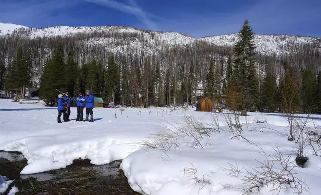 From the California Department of Water Resources, left to right, Angelique Fabbiani-Leon, Jordan Thoennes, Manon von Kaenel, and Andy Reising conduct the first snow survey of the season to assess how much water the state might have come spring and summer at Phillips Station on Thursday, Jan. 2, 2025. (AP Photo/Brooke Hess-Homeier)