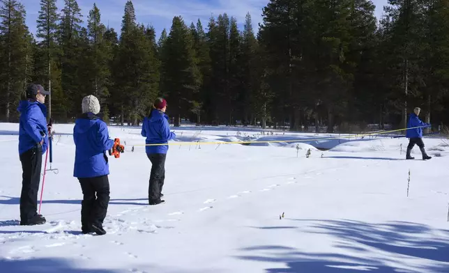 Engineers from the California Department of Water Resources, conduct the first snow survey of the season to assess how much water the state might have come spring and summer at Phillips Station on Thursday, Jan. 2, 2025. (AP Photo/Brooke Hess-Homeier)