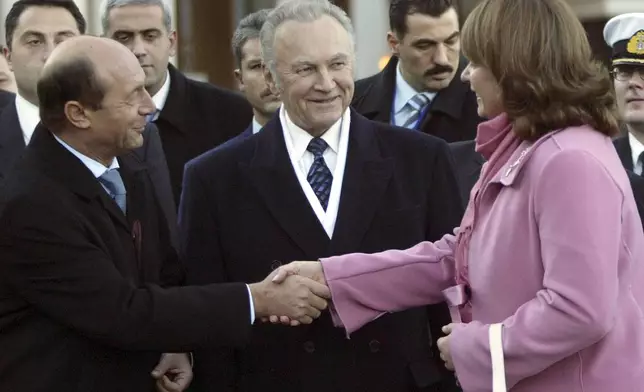 FILE - Georgian President Mikhail Saakashvili's wife, Sandra Roelofs, right, greets Romanian President Traian Basescu, left, and Estonian President Arnold Ruutel, center, during celebrations marking the second anniversary of the Rose Revolution in Tbilisi, Georgia, Wednesday, Nov. 23, 2005. (AP Photo/Shakh Aivazov, File)
