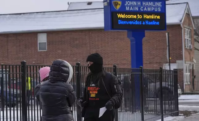 Activist Lapis Marigold with Revcom Corps Chicago talks to people outside of Hamline Elementary School after federal agents were turned away on Friday, Jan. 24, 2025, in Chicago. (AP Photo/Erin Hooley)