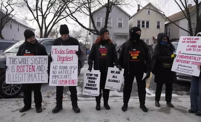 Activists with Revcom Corps Chicago hold signs outside of Hamline Elementary School after federal agents were turned away on Friday, Jan. 24, 2025, in Chicago. (AP Photo/Erin Hooley)