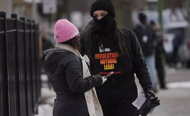 Activist Lapis Marigold with Revcom Corps Chicago talks to people outside of Hamline Elementary School after federal agents were turned away on Friday, Jan. 24, 2025, in Chicago. (AP Photo/Erin Hooley)