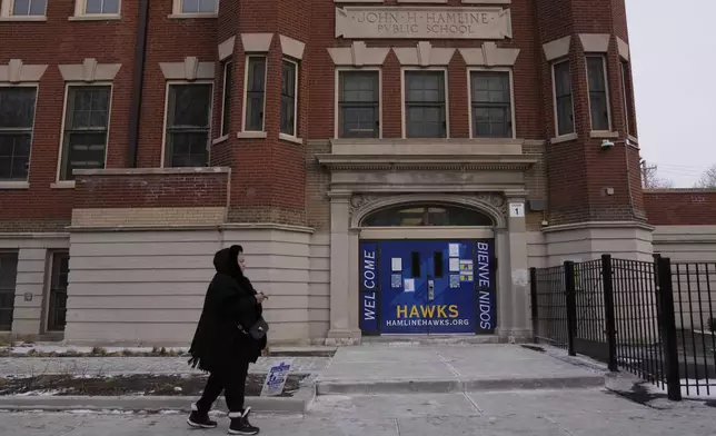 A person walks by Hamline Elementary School after federal agents were turned away on Friday, Jan. 24, 2025, in Chicago. (AP Photo/Erin Hooley)