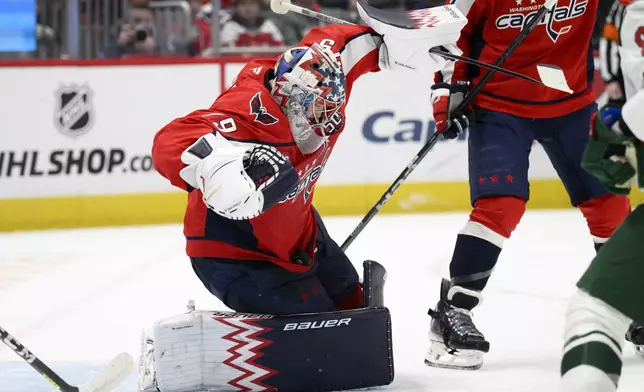 Washington Capitals goaltender Charlie Lindgren (79) stops the puck in his jersey during the second period of an NHL hockey game against the Minnesota Wild, Thursday, Jan. 2, 2025, in Washington. (AP Photo/Nick Wass)