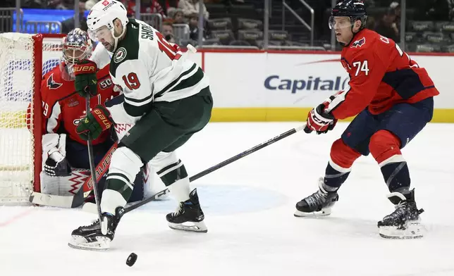 Washington Capitals defenseman John Carlson (74) battles for the puck against Minnesota Wild center Devin Shore (19) during the second period of an NHL hockey game, Thursday, Jan. 2, 2025, in Washington. (AP Photo/Nick Wass)