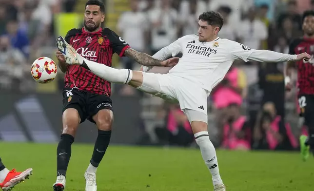 Real Madrid's Federico Valverde, right, is challenged by Mallorca's Omar Mascarell during the Spanish Super Cup semifinal soccer match between Real Madrid and Mallorca at the King Abdullah Stadium in Jeddah, Saudi Arabia, Thursday, Jan. 9, 2025. (AP Photo/Altaf Qadri)