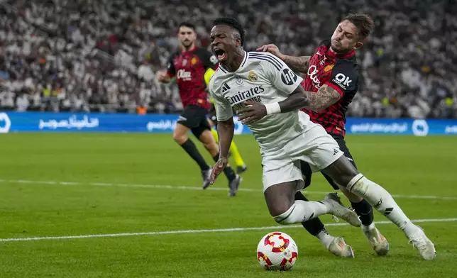 Real Madrid's Rodrygo is challenged by Mallorca's Pablo Maffeo, right, during the Spanish Super Cup semifinal soccer match between Real Madrid and Mallorca at the King Abdullah Stadium in Jeddah, Saudi Arabia, Thursday, Jan. 9, 2025. (AP Photo/Altaf Qadri)