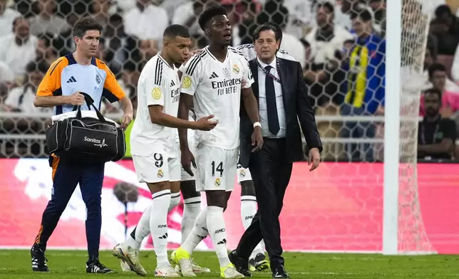 Real Madrid's Aurelien Tchouameni, centre, walks out of field after an injury during the Spanish Super Cup semifinal soccer match between Real Madrid and Mallorca at the King Abdullah Stadium in Jeddah, Saudi Arabia, Thursday, Jan. 9, 2025. (AP Photo/Altaf Qadri)