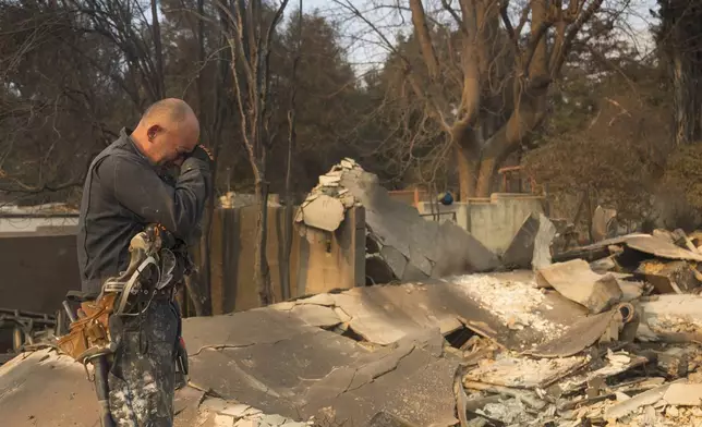 Cesar Plaza becomes emotional while looking at his home destroyed by the Eaton Fire in Altadena, Calif., Thursday, Jan. 9, 2025. (AP Photo/Nic Coury)