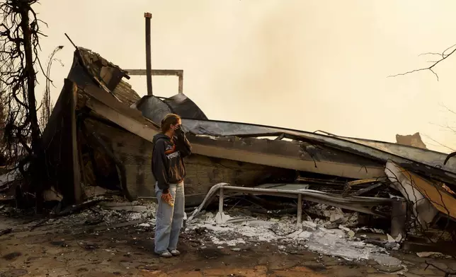 Fallon Prockiw-Kline gets emotional in front of her home which was damaged by the Palisades Fire, Wednesday, Jan. 8, 2025, in Malibu, Calif. (AP Photo/Etienne Laurent)