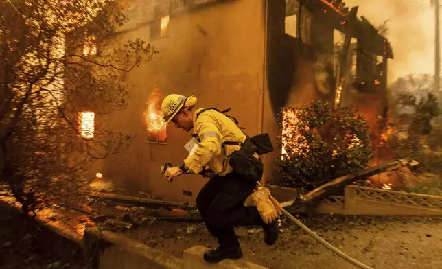 A firefighter battles the Eaton Fire Wednesday, Jan. 8, 2025 in Altadena, Calif. (AP Photo/Ethan Swope)