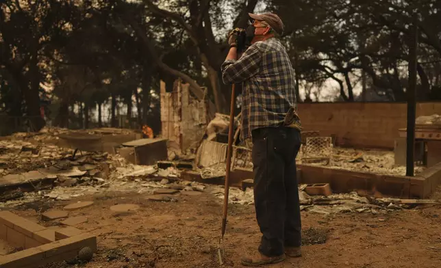 Paul Perri searches through his daughter's fire-ravaged property in the aftermath of the Eaton Fire Thursday, Jan. 9, 2025 in Altadena, Calif. (AP Photo/Eric Thayer)