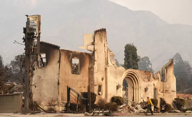 A man walks past the charred remains of the Altadena Community Church, Thursday, Jan. 9, 2025, in the Altadena section of Pasadena, Calif. (AP Photo/Chris Pizzello)