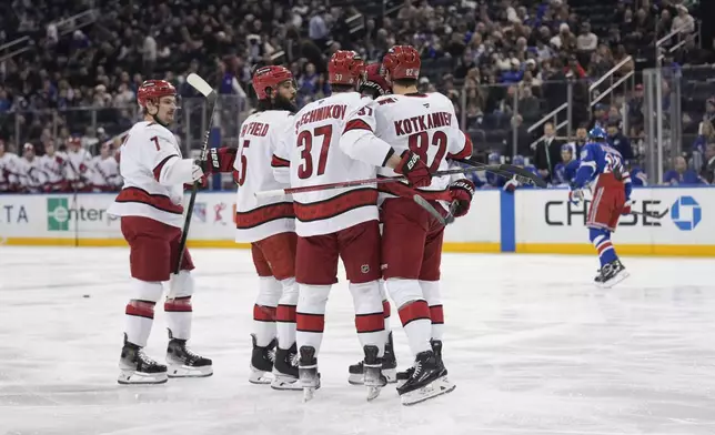 Carolina Hurricanes' Andrei Svechnikov (37), center, celebrates his goal with teammates during the first period of an NHL hockey game against the New York Rangers, Tuesday, Jan. 28, 2025, in New York. (AP Photo/Seth Wenig)