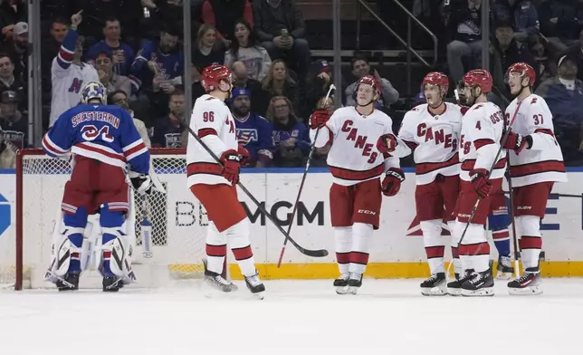 New York Rangers goaltender Igor Shesterkin, left, reacts while Carolina Hurricanes' Andrei Svechnikov, right, celebrates his second goal with teammates during the second period of an NHL hockey game, Tuesday, Jan. 28, 2025, in New York. (AP Photo/Seth Wenig)