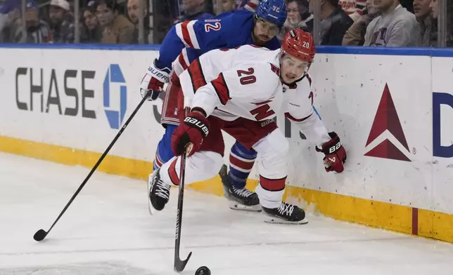 Carolina Hurricanes' Sebastian Aho (20), right, and New York Rangers' Filip Chytil chase the puck during the second period of an NHL hockey game, Tuesday, Jan. 28, 2025, in New York. (AP Photo/Seth Wenig)