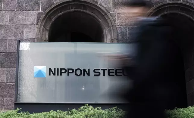 A person walks past a Nippon Steel Corporation sign at the company headquarters Tuesday, Jan. 7, 2025, in Tokyo. (AP Photo/Eugene Hoshiko)