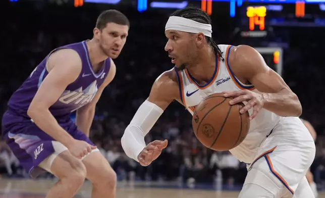 New York Knicks' Josh Hart, right, drives past Utah Jazz's Svi Mykhailiuk during the second half of an NBA basketball game Wednesday, Jan. 1, 2025, in New York. (AP Photo/Frank Franklin II)