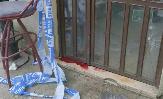 A view of blood by the door of a bar after a shooting incident, in Cetinje, 36 kilometers (22 miles) west of Podogrica, Montenegro, Thursday, Jan. 2, 2025. (AP Photo/Risto Bozovic)