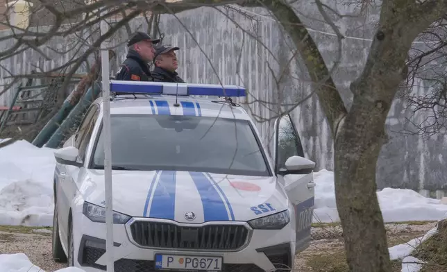 Police officers stand guard at the home of a gunman after a shooting incident, in Cetinje, 36 kilometers (22 miles) west of Podogrica, Montenegro, Thursday, Jan. 2, 2025. (AP Photo/Risto Bozovic)