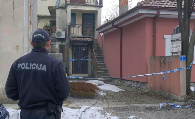 A police officer stands guard at the scene after a shooting incident at a bar, in Cetinje, 36 kilometers (22 miles) west of Podogrica, Montenegro, Thursday, Jan. 2, 2025. (AP Photo/Risto Bozovic)