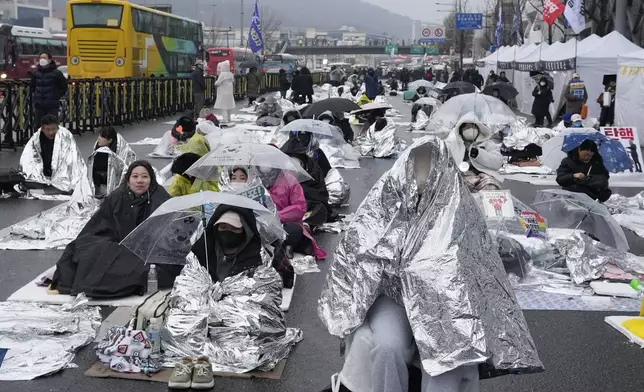 Protesters wait for a rally demanding the arrest of impeached South Korean President Yoon Suk Yeol near the presidential residence in Seoul, South Korea, Monday, Jan. 6, 2025. (AP Photo/Ahn Young-joon)