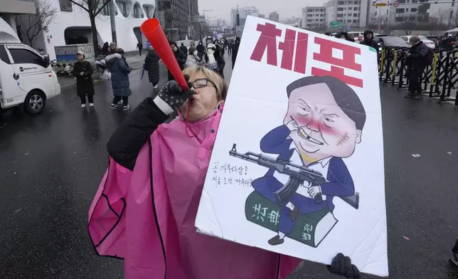 A protester blows a vuvuzela during a rally demanding the arrest of impeached South Korean President Yoon Suk Yeol near the presidential residence in Seoul, South Korea, Monday, Jan. 6, 2025. The letters read "Arrest Yoon Suk Yeol." (AP Photo/Ahn Young-joon)