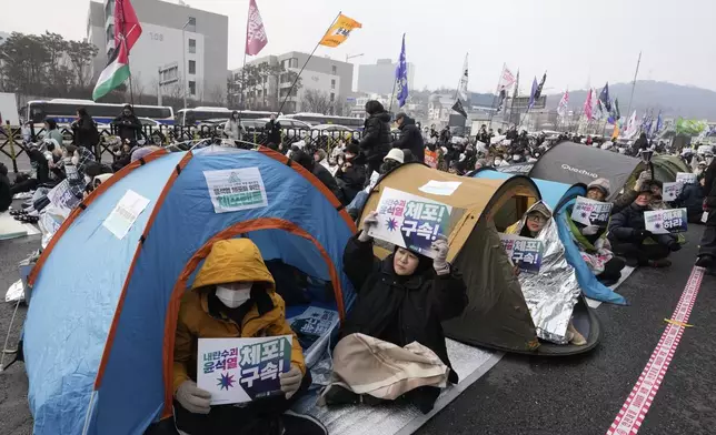 Protesters demanding the arrest of impeached South Korean President Yoon Suk Yeol attend a rally near the presidential residence in Seoul, South Korea, Monday, Jan. 6, 2025. The letters read "Arrest Yoon Suk Yeol." (AP Photo/Ahn Young-joon)