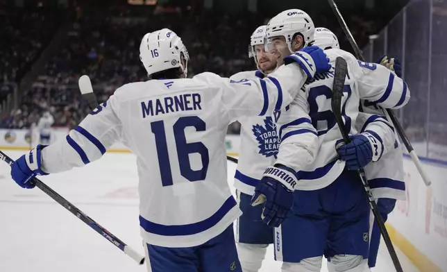 Toronto Maple Leafs' Max Pacioretty (67) and Mitch Marner (16) celebrate with teammates after a goal by Bobby McMann during the third period of an NHL hockey game against the New York Islanders, Thursday, Jan. 2, 2025, in Elmont, N.Y. (AP Photo/Frank Franklin II)