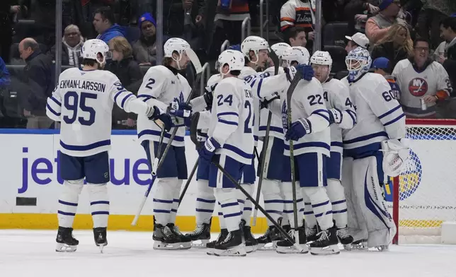 Toronto Maple Leafs goaltender Joseph Woll (60) celebrates with teammates after an NHL hockey game against the New York Islanders, Thursday, Jan. 2, 2025, in Elmont, N.Y. (AP Photo/Frank Franklin II)