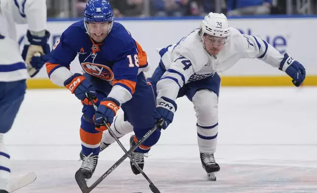 Toronto Maple Leafs' Bobby McMann (74) fights for control of the puck with New York Islanders' Pierre Engvall (18) during the second period of an NHL hockey game, Thursday, Jan. 2, 2025, in Elmont, N.Y. (AP Photo/Frank Franklin II)