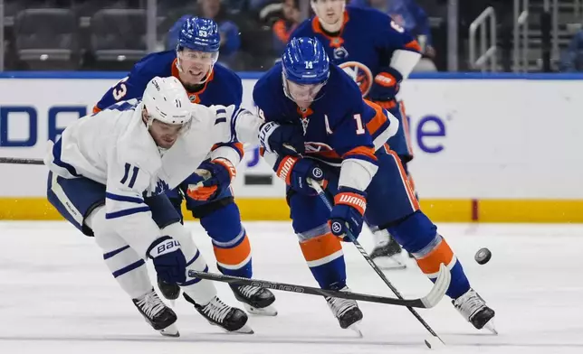 Toronto Maple Leafs' Max Domi (11) fights for control of the puck with New York Islanders' Bo Horvat (14) during the second period of an NHL hockey game, Thursday, Jan. 2, 2025, in Elmont, N.Y. (AP Photo/Frank Franklin II)