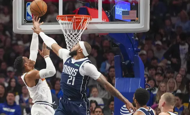 Denver Nuggets guard Russell Westbrook, left, goes up for a shot against Dallas Mavericks center Daniel Gafford (21) during the first half of an NBA basketball game, Sunday, Jan. 12, 2025, in Dallas. (AP Photo/Julio Cortez)