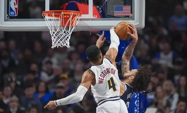 Denver Nuggets guard Russell Westbrook (4) blocks a shot by Dallas Mavericks center Dereck Lively II during the second half of an NBA basketball game, Sunday, Jan. 12, 2025, in Dallas. The Nuggets won 112-101. (AP Photo/Julio Cortez)