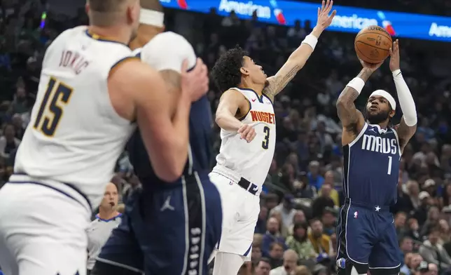 Dallas Mavericks guard Jaden Hardy (1) shoots against Denver Nuggets guard Julian Strawther (3) during the first half of an NBA basketball game, Sunday, Jan. 12, 2025, in Dallas. (AP Photo/Julio Cortez)