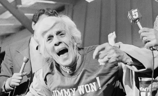 FILE - Lillian Carter, mother of Jimmy Carter, displays her "Jimmy Won!" T-shirt at a train station after Carter was declared the winner in the presidential election, Nov. 3, 1976, in Plains, Ga. (AP Photo, File)