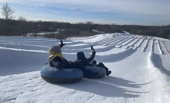 Sisters Ruun Mahamud, left, and Nawal Hirsi go snow tubing during an outing organized by the group Habib founded to promote outdoors activities among Muslim women, at Elm Creek Park Reserve in Maple Grove, Minn., on Jan. 4, 2025. (AP Photo/Giovanna Dell'Orto)