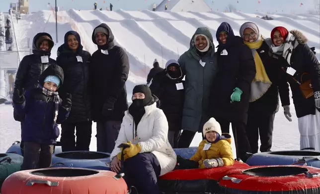 Nasrieen Habib, center right with green coat, and some of the members of the outdoors group she founded for Muslim women pose for a photo at the bottom of a snow tubing hill at Elm Creek Park Reserve in Maple Grove, Minn., on Jan. 4, 2025. (AP Photo/Mark Vancleave)