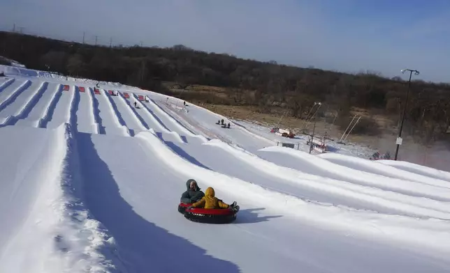 Nasrieen Habib and her four-year-old son go snow tubing during an outing organized by the group Habib founded to promote outdoors activities among Muslim women, at Elm Creek Park Reserve in Maple Grove, Minn., on Jan. 4, 2025. (AP Photo/Giovanna Dell'Orto)