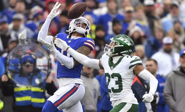 Buffalo Bills wide receiver Keon Coleman (0) makes a catch in front of New York Jets cornerback Isaiah Oliver (23) during the first half of an NFL football game, Sunday, Dec. 29, 2024, in Orchard Park, N.Y. (AP Photo/Adrian Kraus)